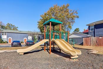 A playground with a green roof and a yellow slide.